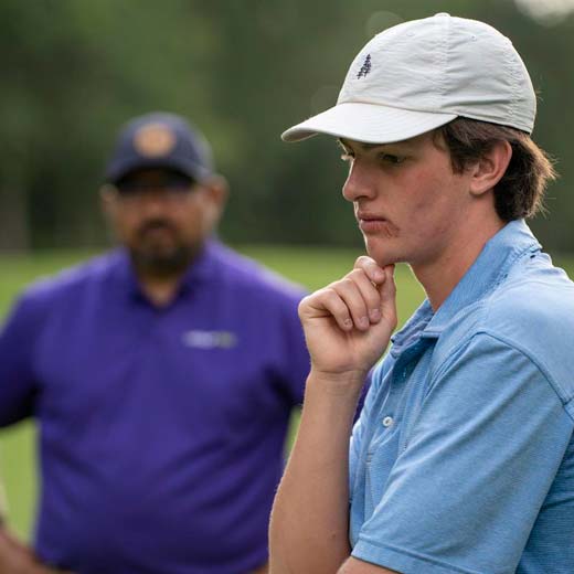 Boy with GOLFTEC coach working on game