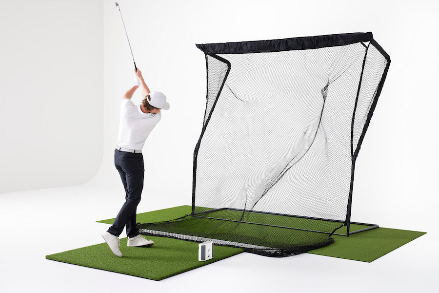 Man hitting on the SkyTrak+ Golf Simulator Practice Studio with the SkyTrak+ launch monitor